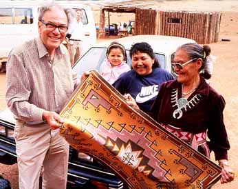 Suzie Yazzie and family members admire one of Tony Shuffrey's tapestry rugs